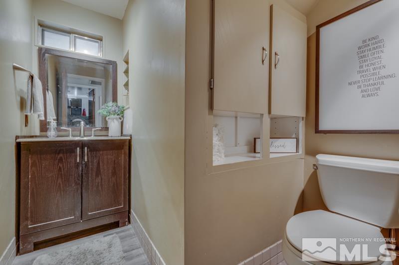 6023 Warm River Road Reno, NV 89523 - Photo 12 of 23 a bathroom with a toilet a sink and mirror