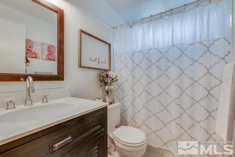 6023 Warm River Road Reno, NV 89523 - Photo 19 of 23 a bathroom with a sink a toilet and a mirror