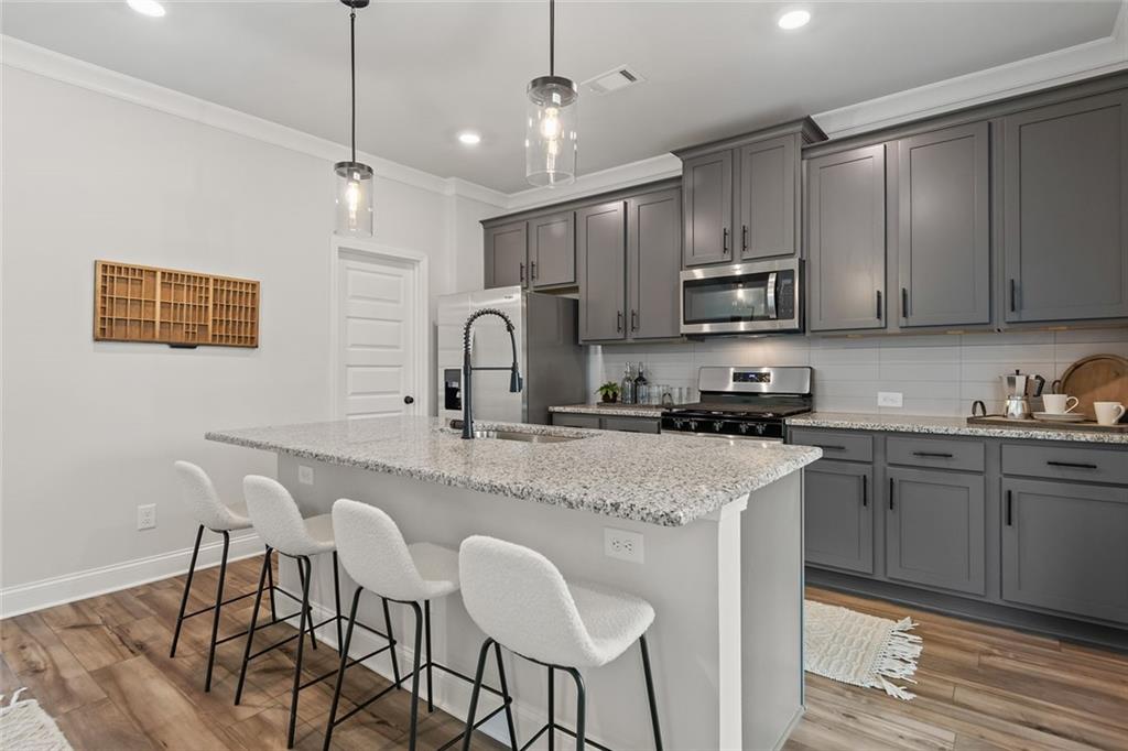 73 Cardinal Pond Lane Winder, GA 30680 - Photo 15 of 59 a kitchen with stainless steel appliances granite countertop a sink a stove a refrigerator cabinets and chairs