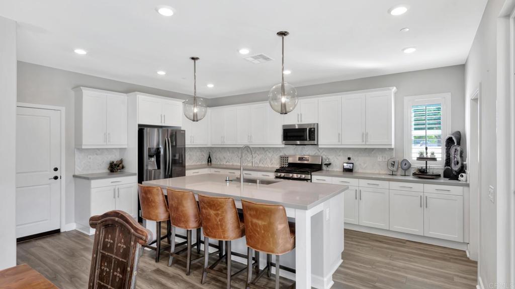 2904 Starry Night Drive Escondido, CA 92029 - Photo 2 of 54 a kitchen with stainless steel appliances kitchen island a stove a sink a refrigerator a center island and a cabinets