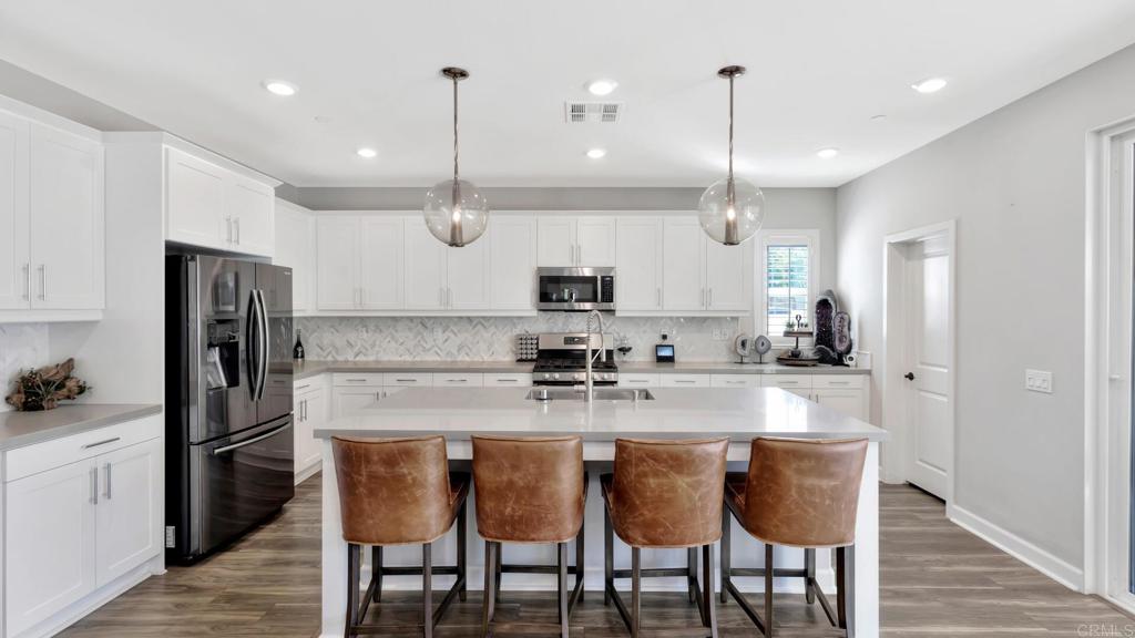 2904 Starry Night Drive Escondido, CA 92029 - Photo 3 of 54 a kitchen with kitchen island granite countertop a sink a center island stainless steel appliances and cabinets