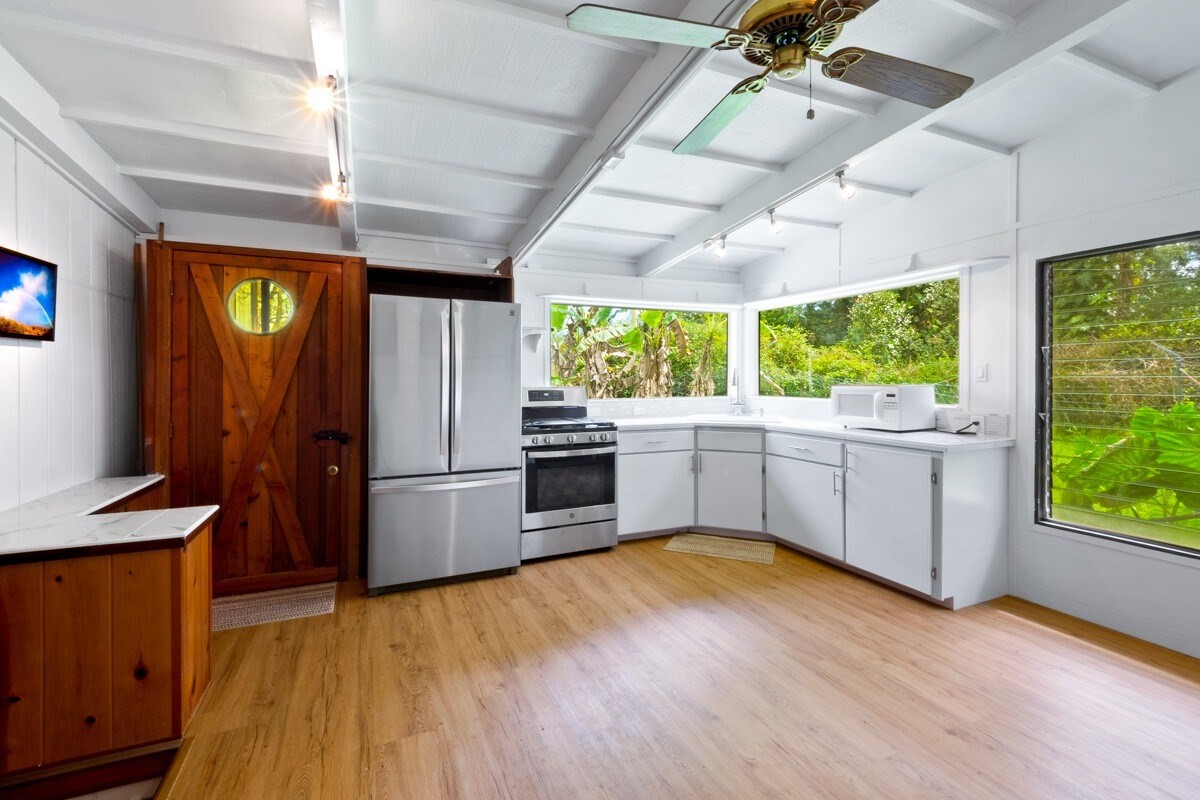 16-2006 Uhini Ana Road Mountain View, HI 96771 - Photo 18 of 25 a kitchen with a wooden floor and a refrigerator