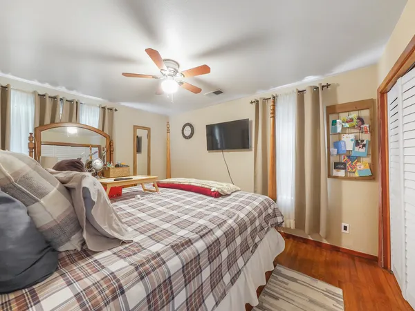 a bedroom with a bed and wooden floor