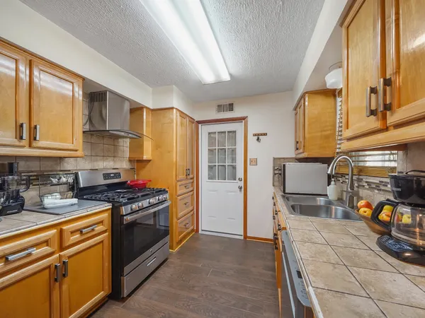 a kitchen with stainless steel appliances granite countertop a stove and a refrigerator