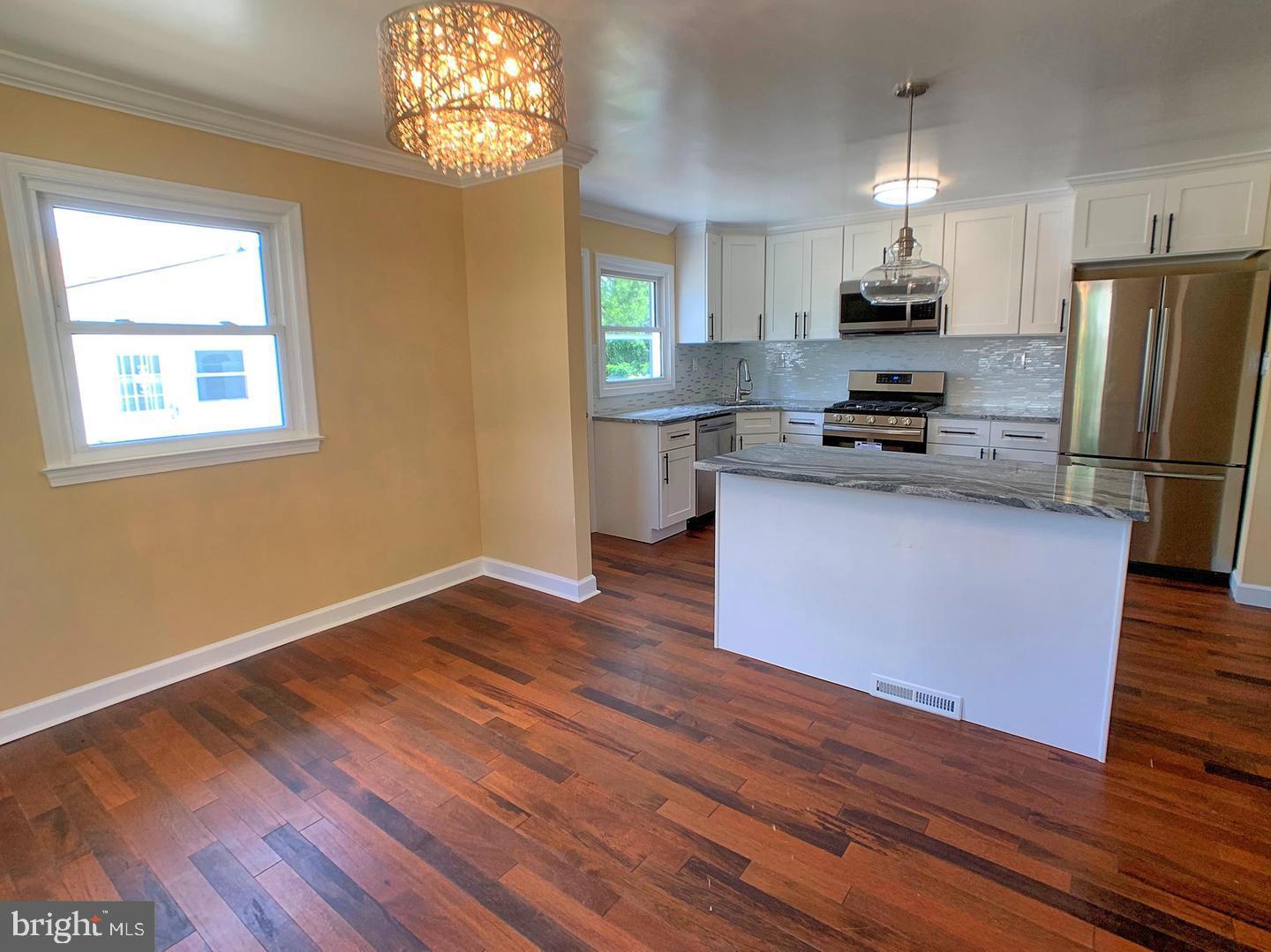 7907 Subet Road Windsor Mill, MD 21244 - Photo 10 of 31 a kitchen with granite countertop wooden floors and stainless steel appliances