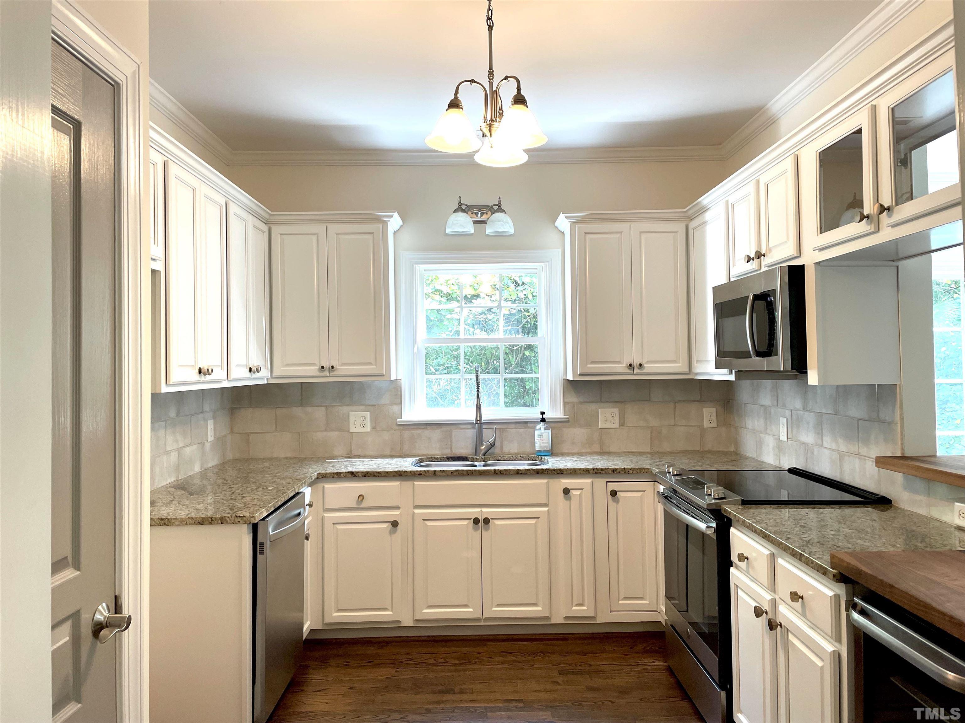 7510 Lead Mine Road, Unit 102 Raleigh, NC 27615 - Photo 2 of 25 a kitchen with stainless steel appliances granite countertop a sink a stove and a microwave