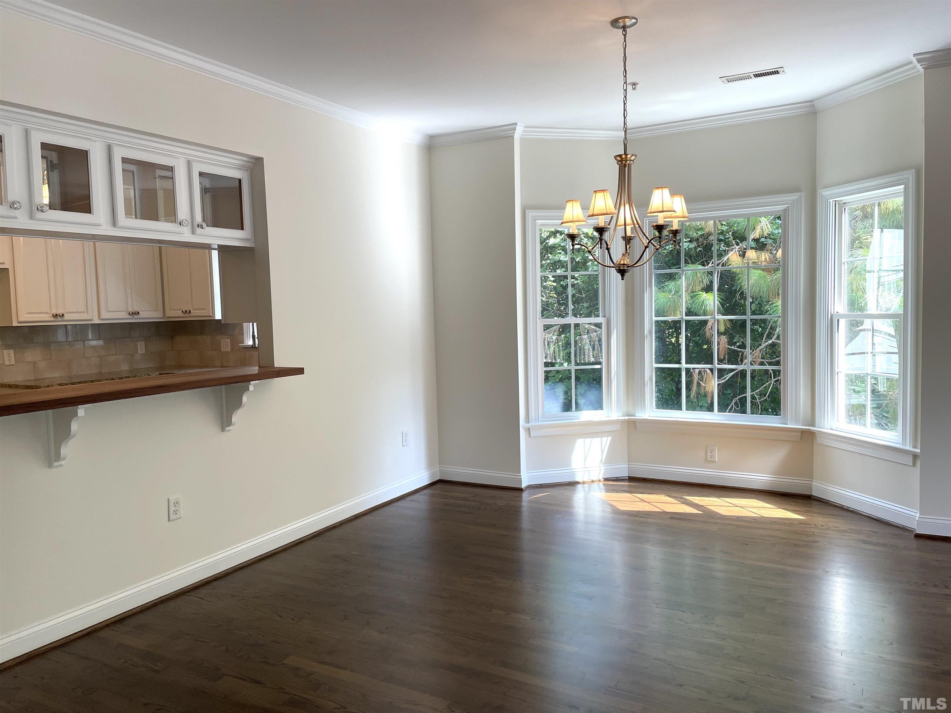 7510 Lead Mine Road, Unit 102 Raleigh, NC 27615 - Photo 5 of 25 a view of an empty room with wooden floor and a window