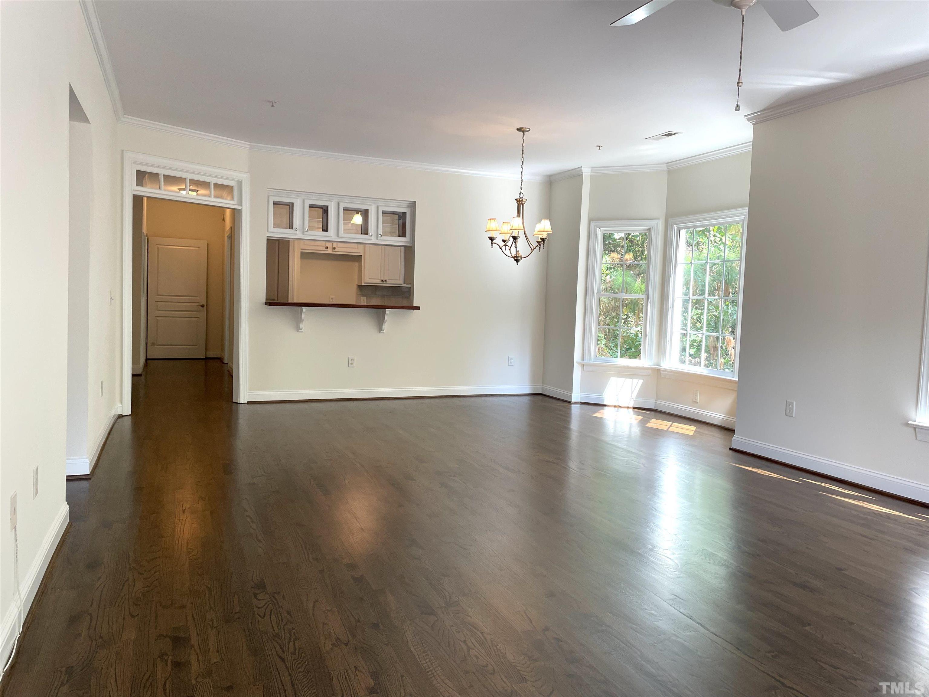 7510 Lead Mine Road, Unit 102 Raleigh, NC 27615 - Photo 6 of 25 an empty room with wooden floor and windows