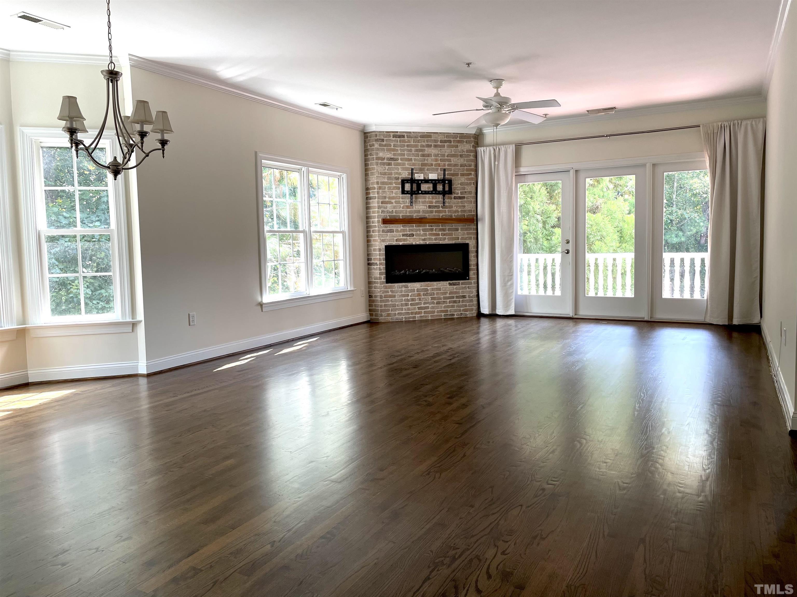 7510 Lead Mine Road, Unit 102 Raleigh, NC 27615 - Photo 8 of 25 a view of a big room with wooden floor fireplace and windows