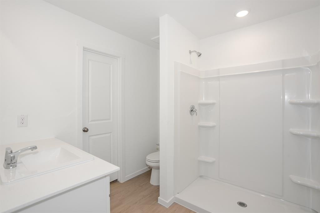 1419 Merlin Blf Street Forney, TX 75126 - Photo 12 of 24 Bathroom featuring a white vanity with an integrated sink, chrome faucet, and wood-finish flooring