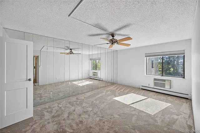 a view of a livingroom with a ceiling fan & windows