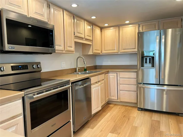 a kitchen with stainless steel appliances a stove microwave and sink