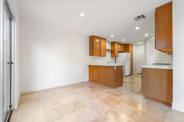 a view of a kitchen with kitchen island granite countertop a sink and a refrigerator