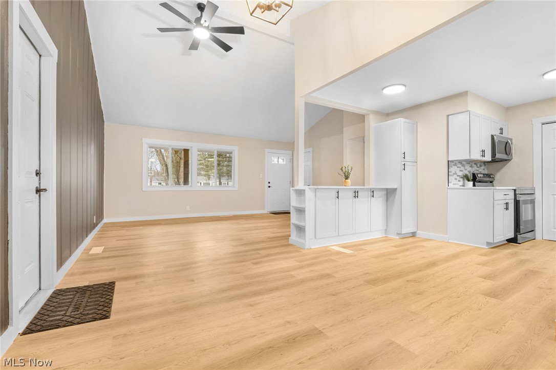 8304 Cedar Road Chesterland, OH 44026 - Photo 10 of 31 Unfurnished living room featuring a ceiling fan, light wood-style flooring, and vaulted ceiling