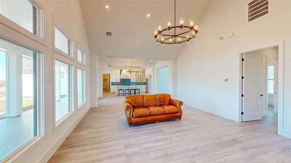 a view of an empty room with wooden floor and window