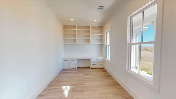 a very nice looking room with a large kitchen counter space and wooden floor
