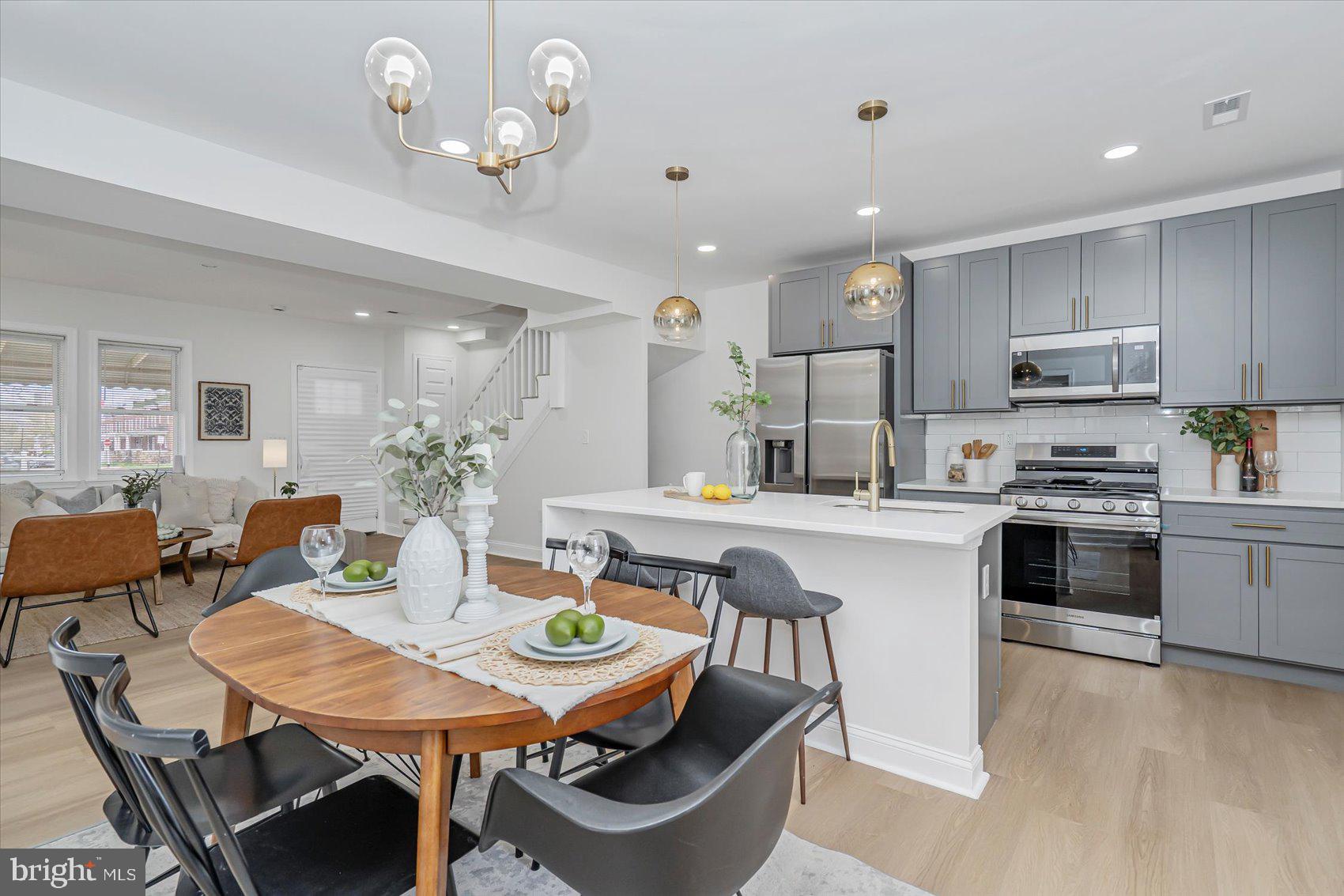 a kitchen with kitchen island a dining table and chairs