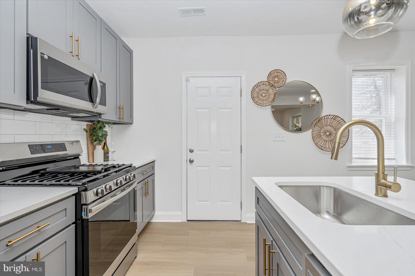 5412 Clover Road Baltimore, MD 21215 - Photo 14 of 42 a kitchen with stainless steel appliances granite countertop a sink and a stove top oven
