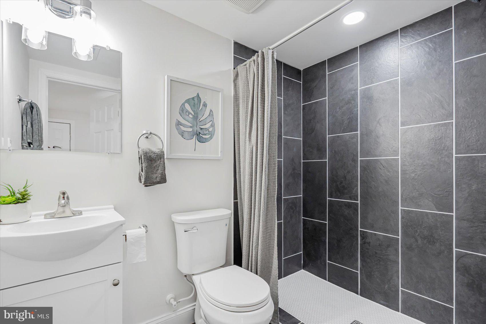 5412 Clover Road Baltimore, MD 21215 - Photo 21 of 42 a bathroom with a toilet sink vanity and shower