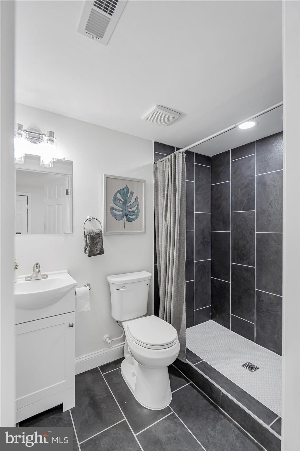 5412 Clover Road Baltimore, MD 21215 - Photo 22 of 42 a bathroom with a sink a toilet and shower