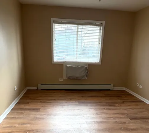 a view of a small space with wooden floor and a window
