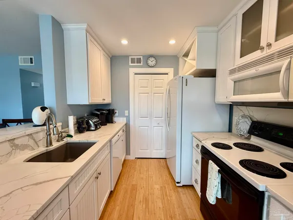 a kitchen with a sink stove top oven and refrigerator