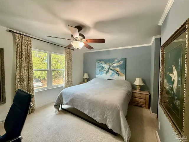 a bedroom with a bed dresser and a large window