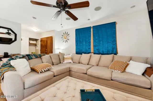a living room with furniture and a ceiling fan