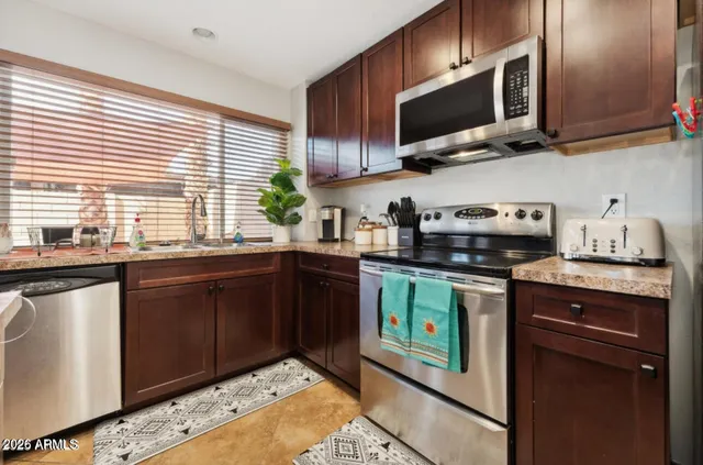 a kitchen with stainless steel appliances granite countertop a sink and a stove