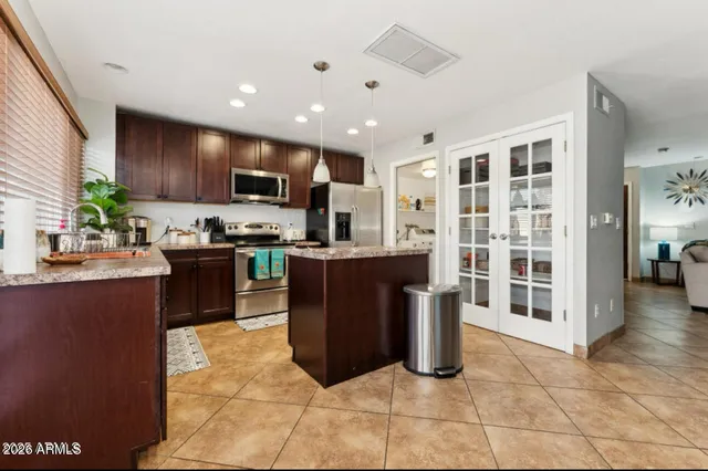 a kitchen with stainless steel appliances granite countertop a stove top oven a sink a counter top space and cabinets