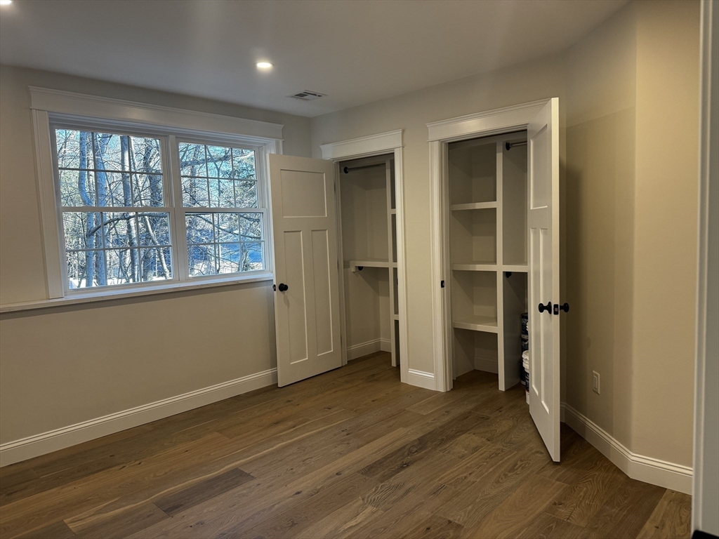 1 A Old Mill Road, Unit 2 Maynard, MA 01754 - Photo 6 of 11 an empty room with wooden floor and windows