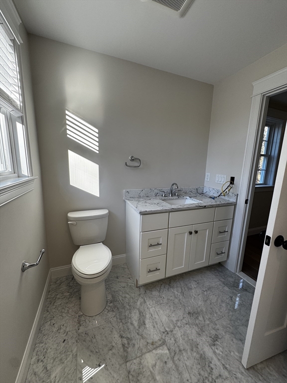 1 A Old Mill Road, Unit 2 Maynard, MA 01754 - Photo 8 of 11 a bathroom with a granite countertop toilet sink and mirror