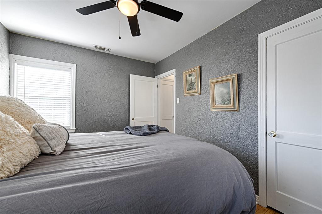 1707 Homewood Place Dallas, TX 75224 - Photo 12 of 21 a bedroom with a large bed and a chandelier