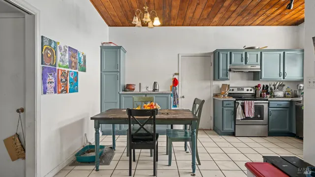 a kitchen with stainless steel appliances kitchen island granite countertop a table and chairs in it