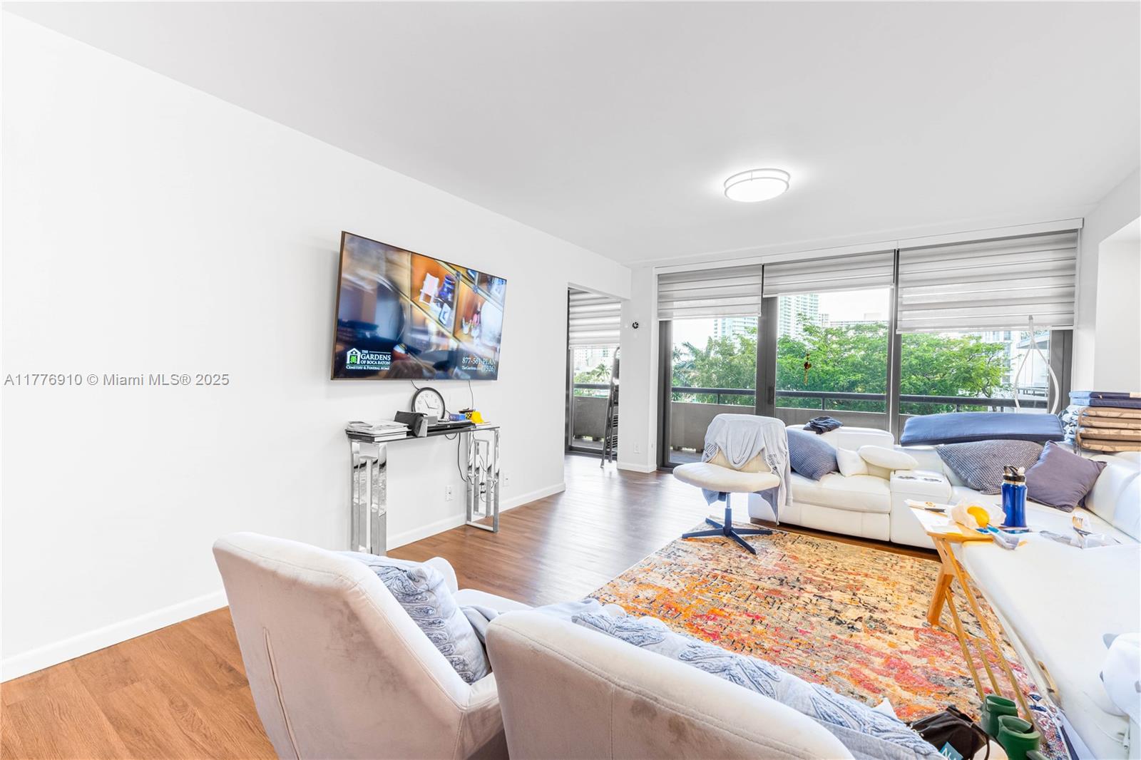 a living room with furniture large window and a flat screen tv
