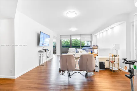 a living room with furniture floor to ceiling window and wooden floor