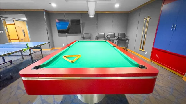 a room with pool table and windows