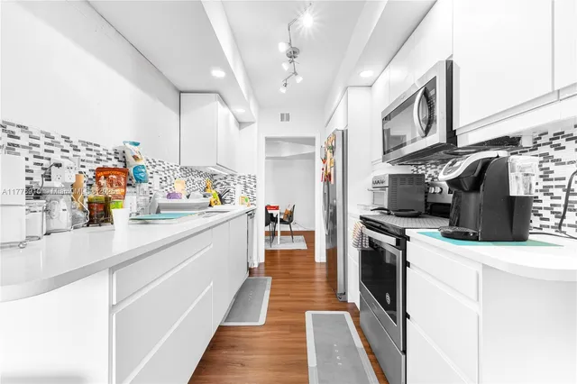 a kitchen with stainless steel appliances a stove refrigerator sink and cabinets