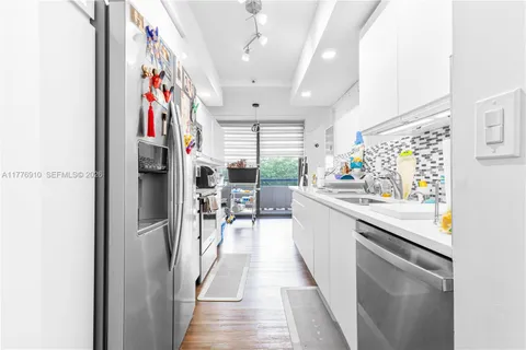 a kitchen with stainless steel appliances granite countertop a refrigerator and a sink