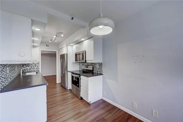 a kitchen with stainless steel appliances granite countertop a sink and a stove top oven