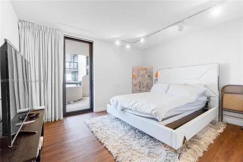 a white bed sitting in a bedroom next to a window