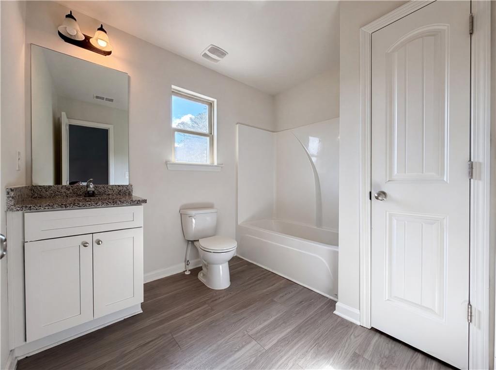4075 McClendon Way Rex, GA 30273 - Photo 21 of 25 a bathroom with a toilet a sink and mirror