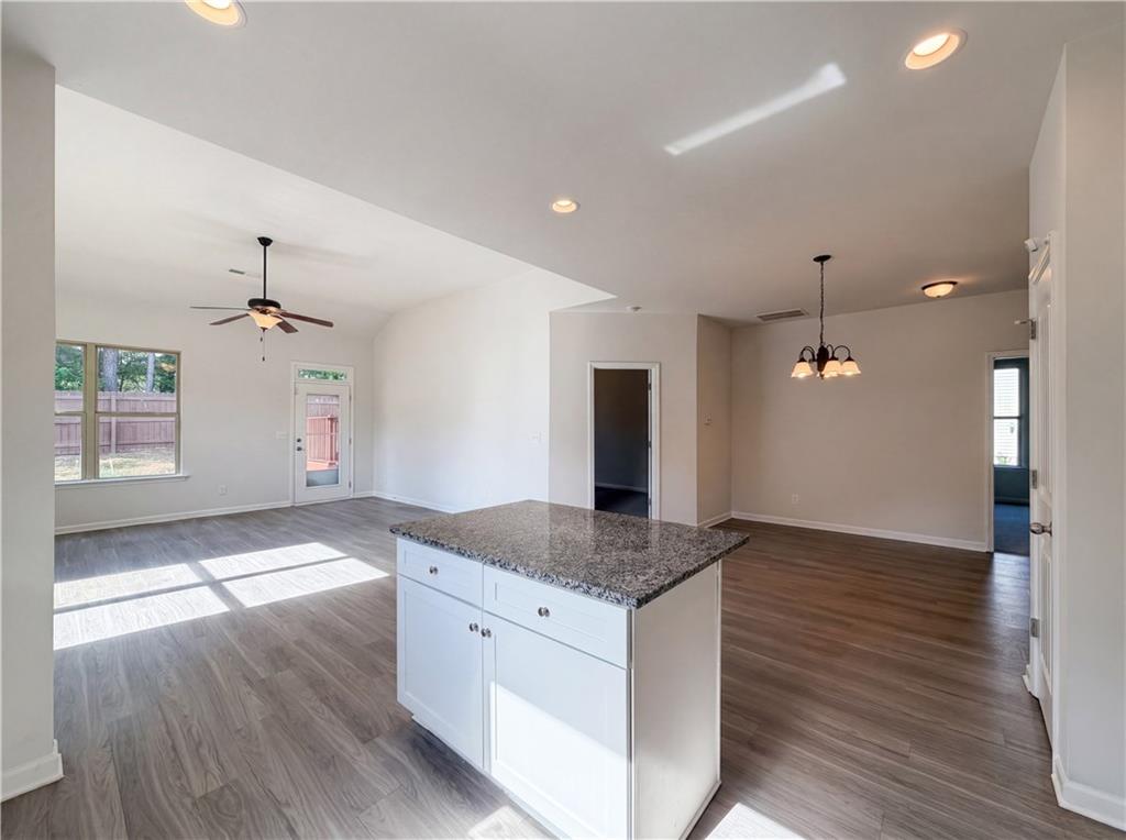 4075 McClendon Way Rex, GA 30273 - Photo 8 of 25 a kitchen with granite countertop a stove and a wooden floor