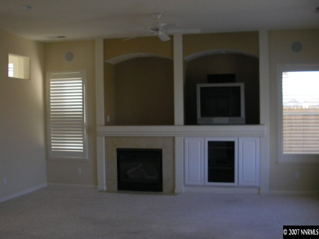 9553 Steep Climb Court Reno, NV 89521 - Photo 7 of 9 a living room with a fireplace and a flat screen tv