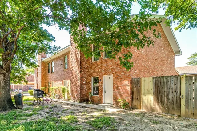 a view of a brick house with a large windows and a big yard