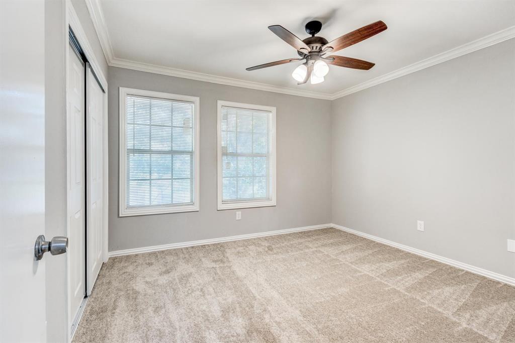 210 Rolston Road, Unit 8 Irving, TX 75060 - Photo 21 of 24 an empty room with chandelier fan and windows