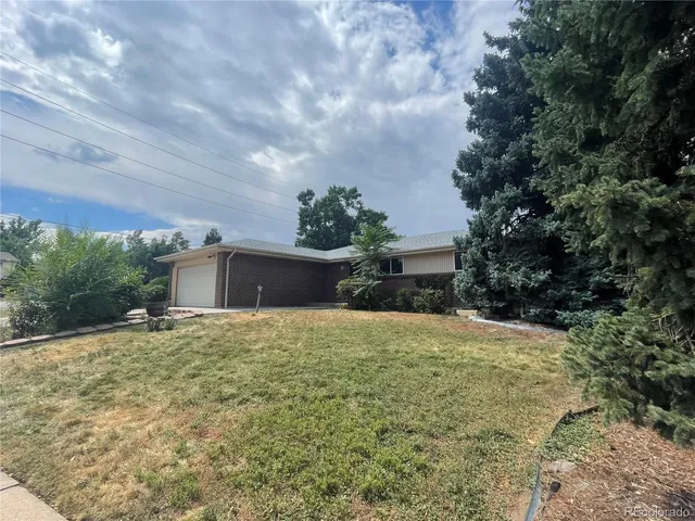 a tall yellow house with a yard in front of it