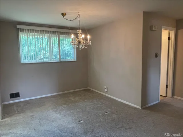 an empty room with windows and cabinet