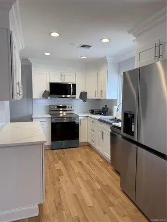 a kitchen with granite countertop a refrigerator sink and wooden cabinets