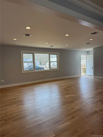 an empty room with wooden floor and entrance